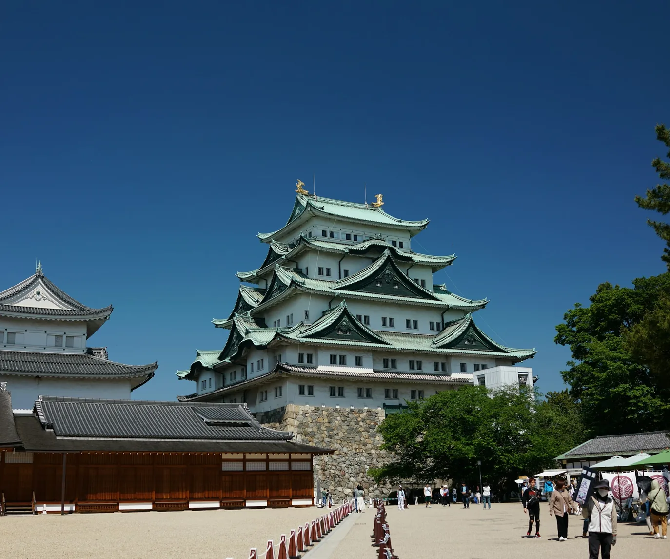 愛知エリア用の緑の木々と城郭を背景にした明るい風景。